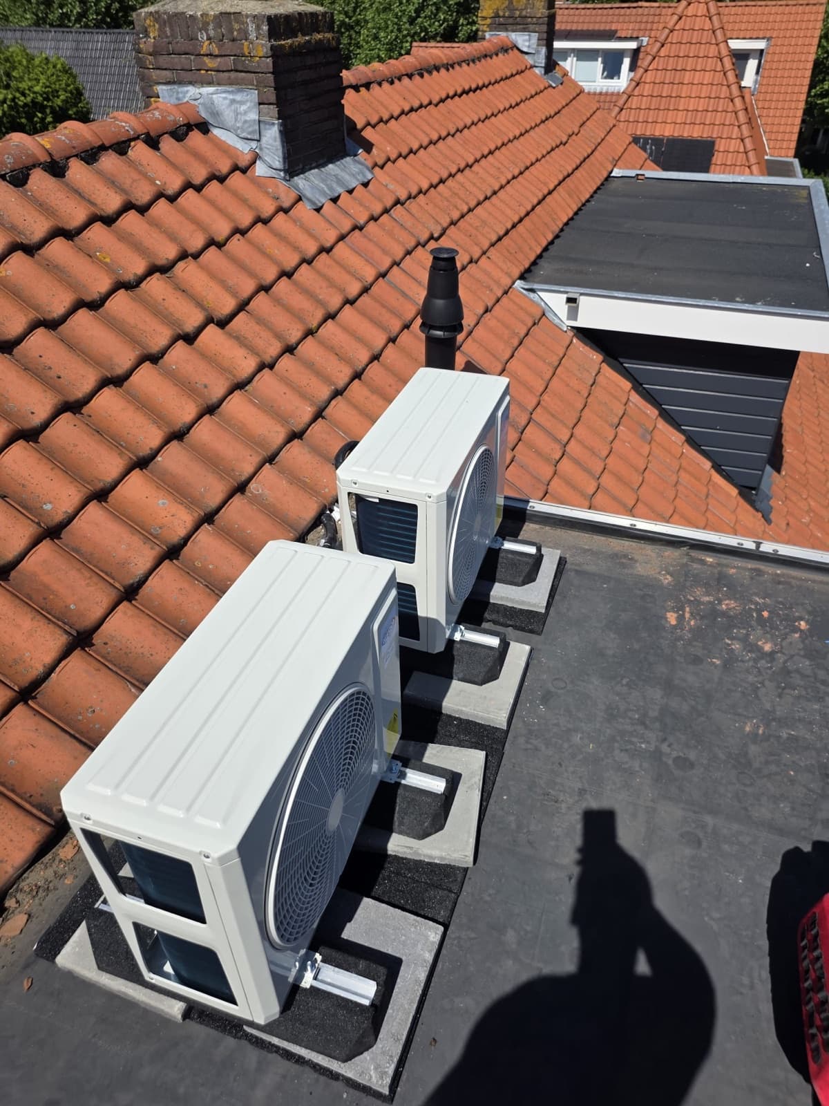 Twee Argo airco-buitenunits trillingsvrij op een plat dak geplaatst bij een klant, netjes weggewerkt